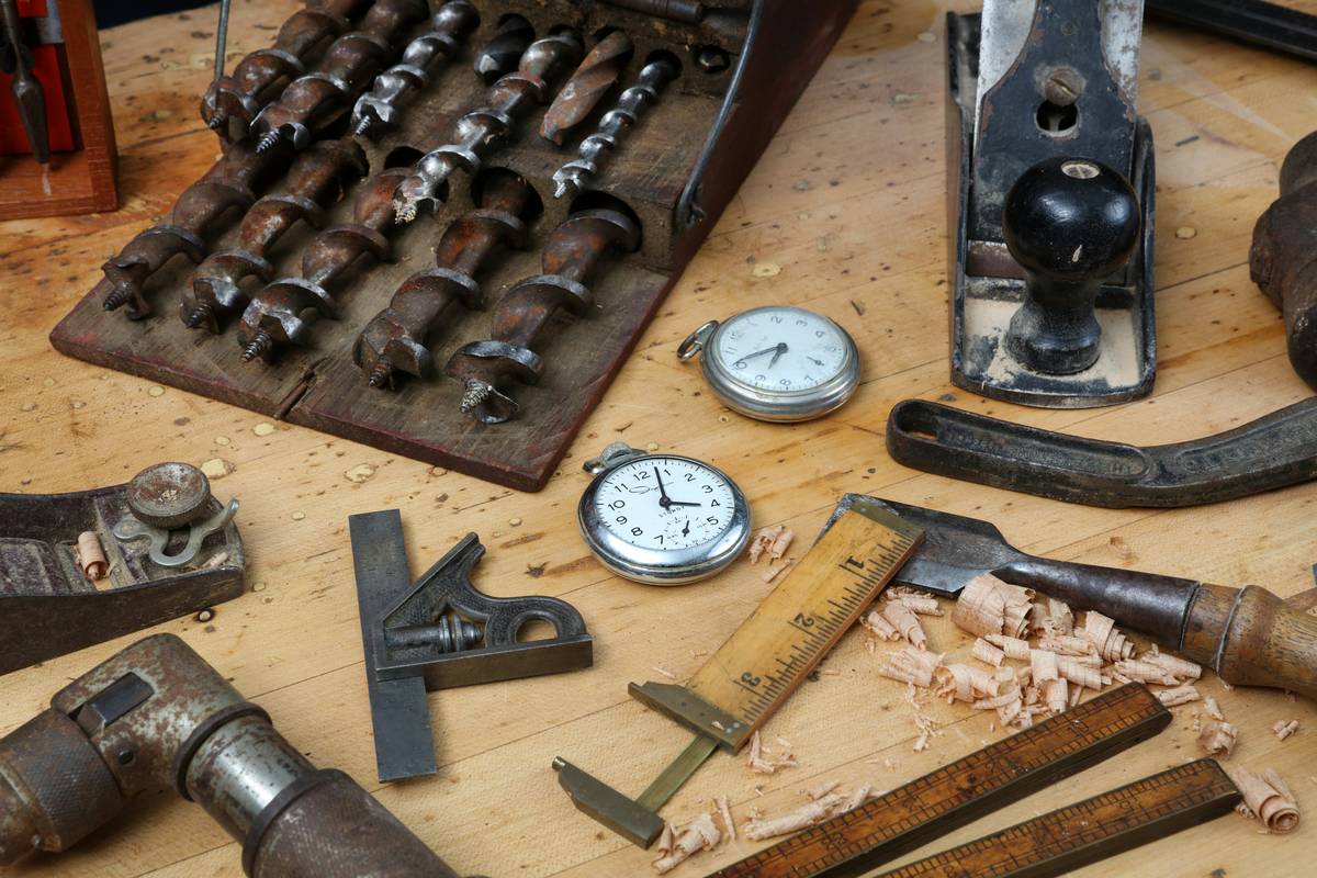 Close-up of hands cleaning mantel clock gears during how to repair a mantel clock process