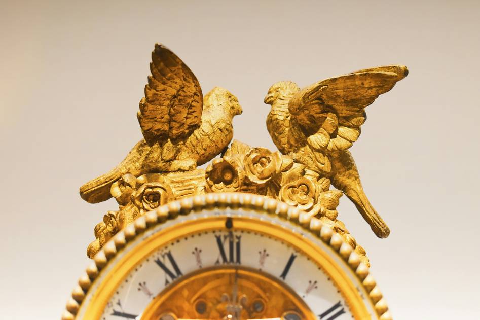 Elegant wooden mantel clock with brass accents on a marble fireplace