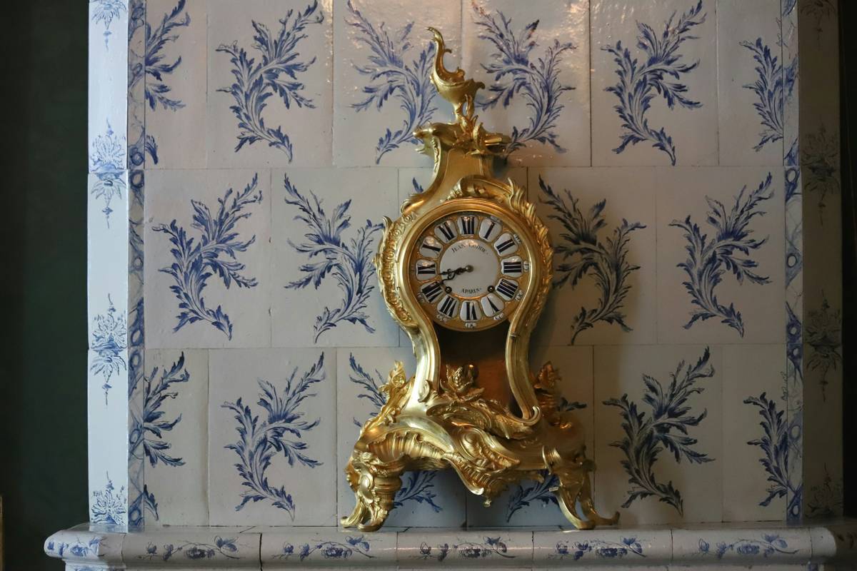 art deco style mantel clocks featuring geometric brass design with black marble base on a traditional fireplace